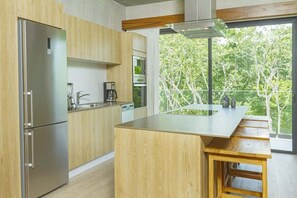A modern kitchen with wooden cabinets, stainless steel appliances, and a large island.