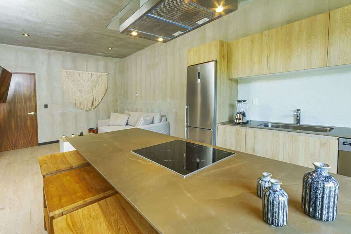 A modern kitchen with a central island, stainless steel appliances, and wooden cabinetry.
