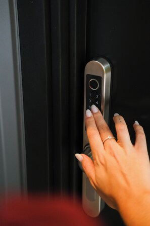 A hand pressing a numeric keypad on a door lock. - Primo Cabana - Hospedagem na Vinícola (Quatro Barras)
