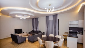 Una sala de estar moderna con sofá, televisor y comedor.