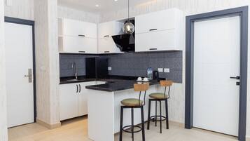 Suite estudio empresarial, vista a la ciudad | Cocina privada | Horno, parrilla de estufa, lavavajillas y tetera eléctrica