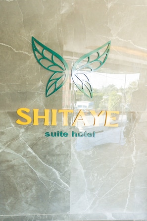 A hotel sign with a butterfly logo and the name "SHITAYE suite hotel" on a marble surface. - Shitaye Suite Hotel (Addis Ababa)