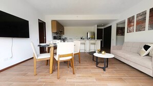A modern living room with a sofa, dining table, chairs, and a coffee table. - PanoramaTWR 2Brm Short walk to everything Pool&Gym

 (San Salvador)