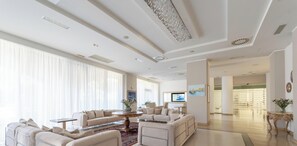 Un salón amplio con un conjunto de sofás, una mesa de centro y un televisor.