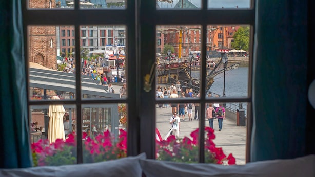 A window view of a busy street with people, a bridge, and buildings. - Motlawa Apartments - Old Town by the river, Fast Wifi (Gdansk)