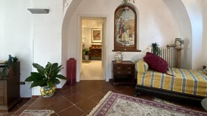 A bedroom with a bed, a hanging plant, a mirror, and a door leading to another room. - Suite 1744 (Meta)