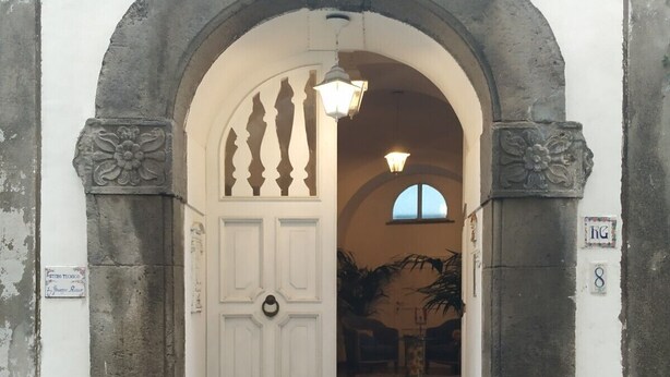 An entrance with a white door, stone archway, and a small window above. - Suite 1744 (Meta)