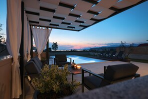 Ein Außenbereich mit Pool, Stühlen und einem Tisch mit Kerzen.