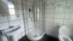 Une salle de bain avec une douche à parois de verre, un lavabo et des toilettes.