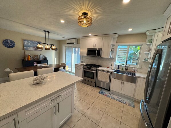 A modern kitchen with white cabinets, stainless steel appliances, and a central island.