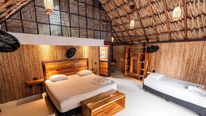 Une pièce avec un plafond haut, des murs en bois, un lit avec une tête de lit en bois, un banc et une armoire.