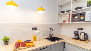 Uma cozinha moderna com pia, bancada e luminárias pendentes amarelas.