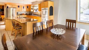 Une cuisine moderne avec des meubles en bois, des appareils électroménagers en acier inoxydable et un îlot central.