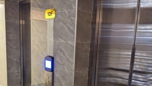 A modern elevator with a digital display and a sign indicating the floor number 10F.