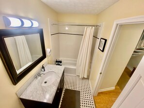 A bathroom with a marble sink, a shower with a glass door, and a mirror with a black frame. - Condo Wintergreen pet Friendly Pool Access (Nellysford)