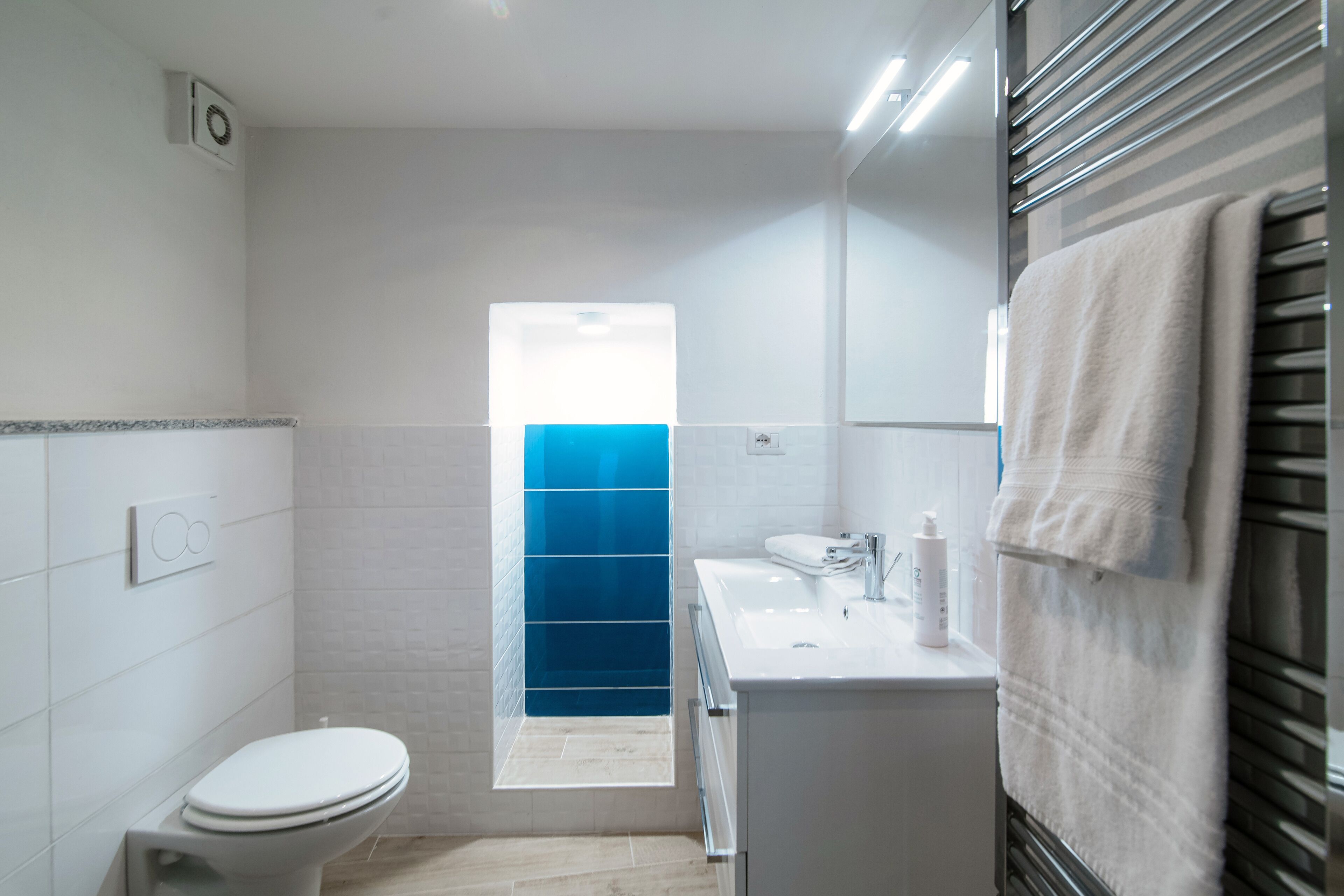 Un bagno moderno con il water, un lavandino e un porta asciugamani.