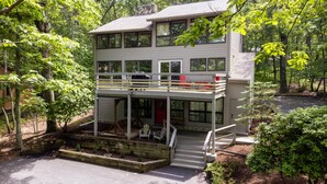 A two-story house with a balcony, surrounded by trees. - Wintergreen Retreat Jacuzzi Sauna dog Friendly (Nellysford)