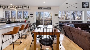 A modern kitchen with a dining area, large windows, and a cozy seating area. - Wintergreen Retreat Jacuzzi Sauna dog Friendly (Nellysford)