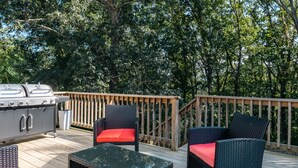 An outdoor deck with wicker furniture, a grill, and a wooden railing. - Waynesboro Home Near Wintergreen Charlottesville (Waynesboro)