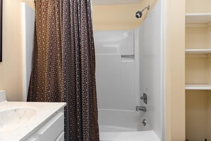 A bathroom with a shower, a toilet, and a sink.