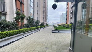 En asfalterad gångväg med en låg mur på ena sidan och en byggnad på den andra.