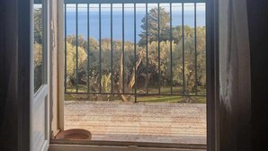 A room with a view of the sea through a balcony with a metal railing. - Jolie Maison Entre Mer et Montagne (Brando)