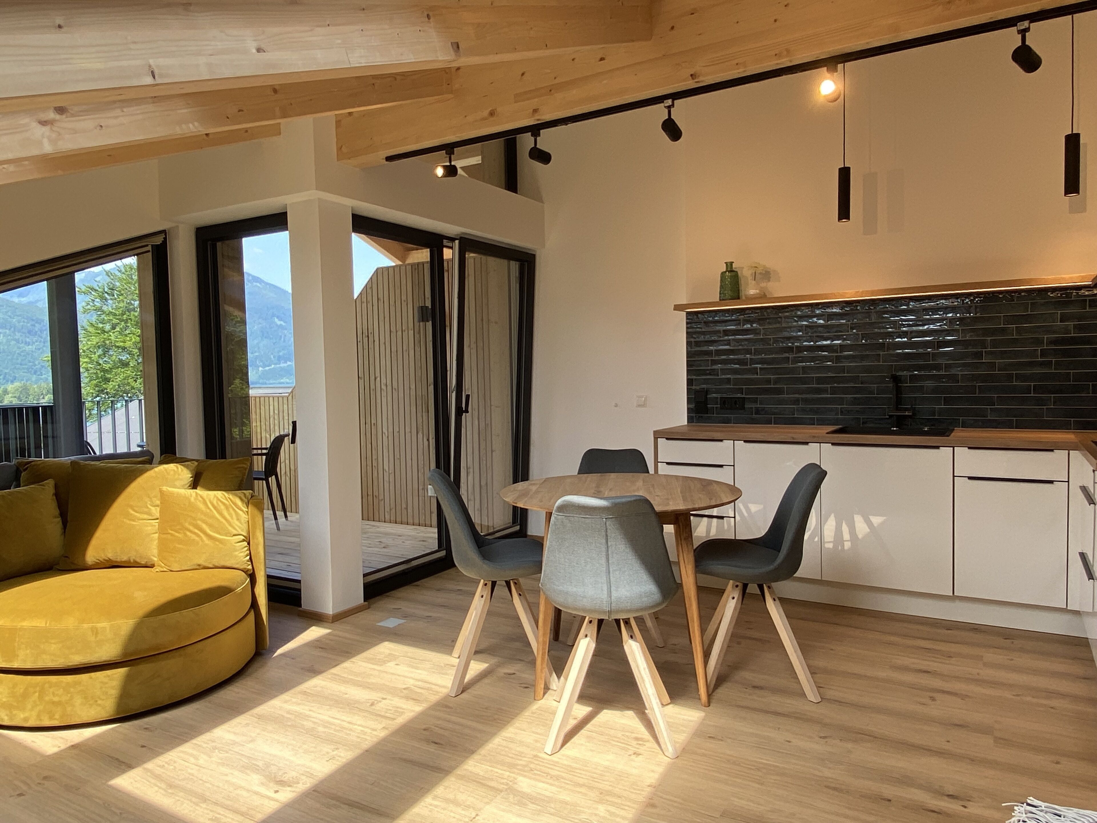 Eine moderne Küche mit schwarzem Fliesenspiegel und Holzschränken.