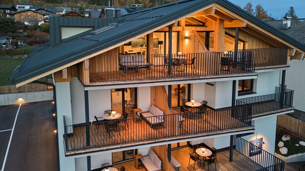 A multi-story building with outdoor terraces, balconies, and a covered outdoor dining area. - Wolf & Schaf Apartments (St. Gilgen)