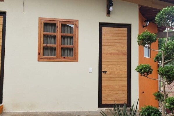 Stunning building facade with a single window and door, featuring a wooden frame and a small garden.