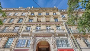 A multi-story building with ornate architectural details, including a central archway and balconies.