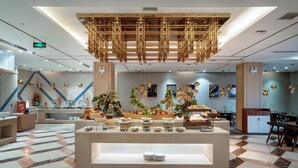 A modern hotel lobby with a central buffet area, check-in counters, and a patterned floor. - Grand Madison Hotel Linfen (Linfen)