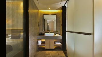 A modern bathroom with a large mirror, a sink, and a shower area.
