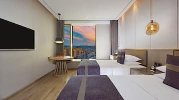 Habitación de hotel moderna con vistas a la ciudad, una cama grande, un escritorio y una zona de estar.