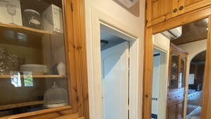 Una cocina de madera con armarios, un expositor de vidrio y un suelo de azulejos azules.