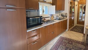 Una cocina con armarios de madera, un microondas y un tapete estampado.