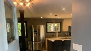 A modern kitchen with stainless steel appliances, a wooden floor, and a built-in island. - The south Bruce peninsula beauty (Wiarton)