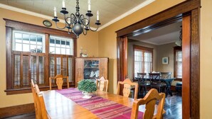 A dining room with a wooden table, chairs, and a chandelier. - JJ’s small town country retreat     (Badjeros)