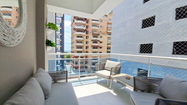 A balcony with a sofa, two chairs, and a small table.