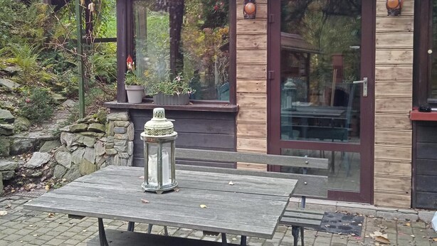 A wooden deck with a table and benches, surrounded by stone walls and potted plants. - Cottage in the Picturesque Beskid Maly Mountains (Porabka)