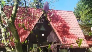 A house with a red tiled roof, a visible chimney, and a front door. - Cottage in the Picturesque Beskid Maly Mountains (Porabka)