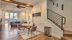 Un vaste espace de vie comprenant une table à manger, des chaises, un canapé et un escalier.
