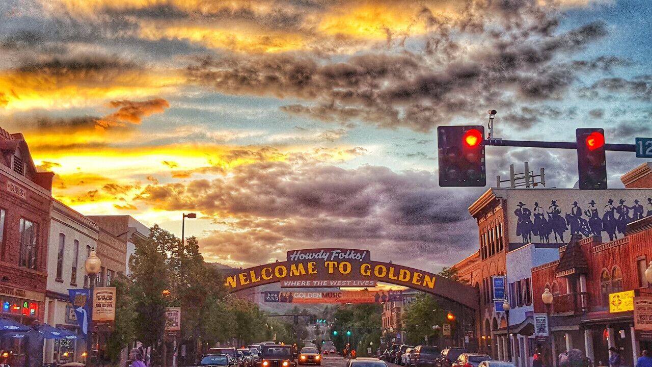 A street scene with a 'Welcome to Golden' sign, buildings, and traffic lights.