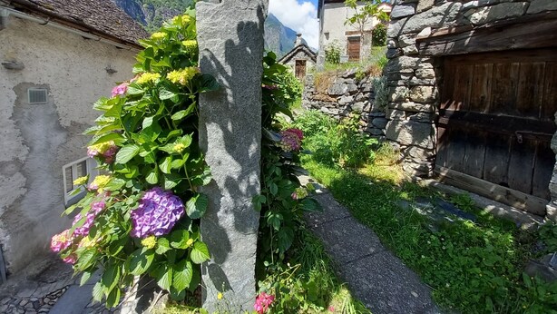 A narrow stone pathway leading to traditional stone buildings with a mountain backdrop. - Room-"casa Coerente" Cavergno - Rooms #1 (Cevio)
