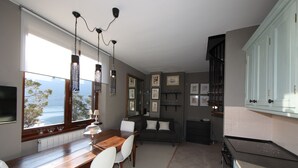 Eine moderne Küche mit Essbereich, großen Fenstern und Meerblick.