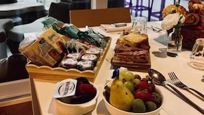 Un bufé de desayuno con diferentes opciones de comida y un tazón de fruta.