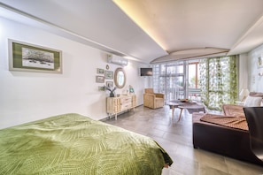 A modern living room with a sofa, a coffee table, a TV, and a large window with curtains. - Magical View Studios 1 Asproneri, Kamena Vourla (Kamena Vourla)