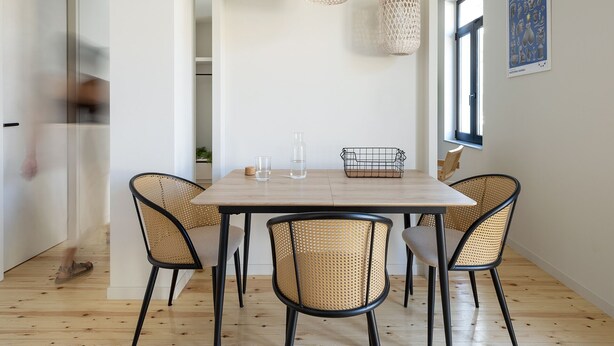 A dining area with a wooden table, four wicker chairs, two woven pendant lights, and a glass vase on the table. - Hoppersgr- Amazing apt in the heart of Athens - 1
 (Athina)