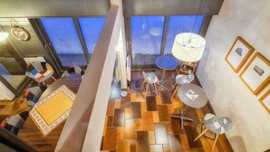Een modern interieur met grote ramen, een betegelde vloer en meerdere tafels en stoelen.