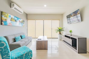 A modern living room with a sofa, a coffee table, and a TV stand. - Lujoso Condominio Tiburon a 3 Cuadras de la Playa (Mazatlán)