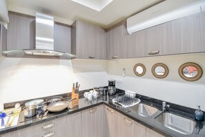Una cocina moderna con estufa a gas, pileta de acero inoxidable y armarios de madera.
